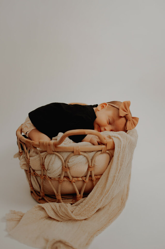 Baby in a rattan basket in photo studio in Queensbury, New York